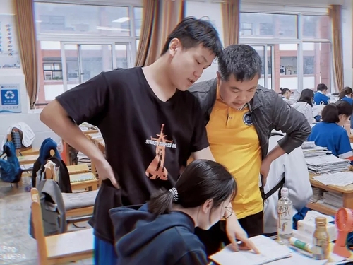 课间休息时，刘劲松主任在教室辅导学生